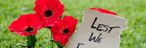 Poppy flowers with a little paper sign saying "Lest we forget"