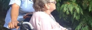 Nurse with patient in nursing home taking a walk outside