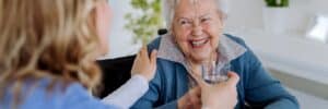 Nurse handing water to a resident of a nursing home